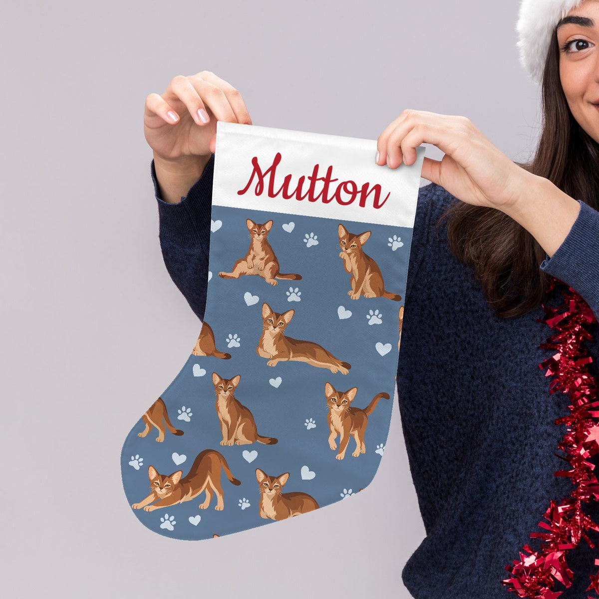 Abyssinian Christmas stocking on slate blue background with example name Mutton in red script on the white cuff; view 5.