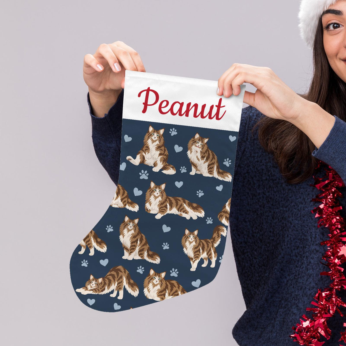 Norwegian Forest Cat Christmas stocking on deep navy background with example name Peanut in red script on the white cuff; view 5.