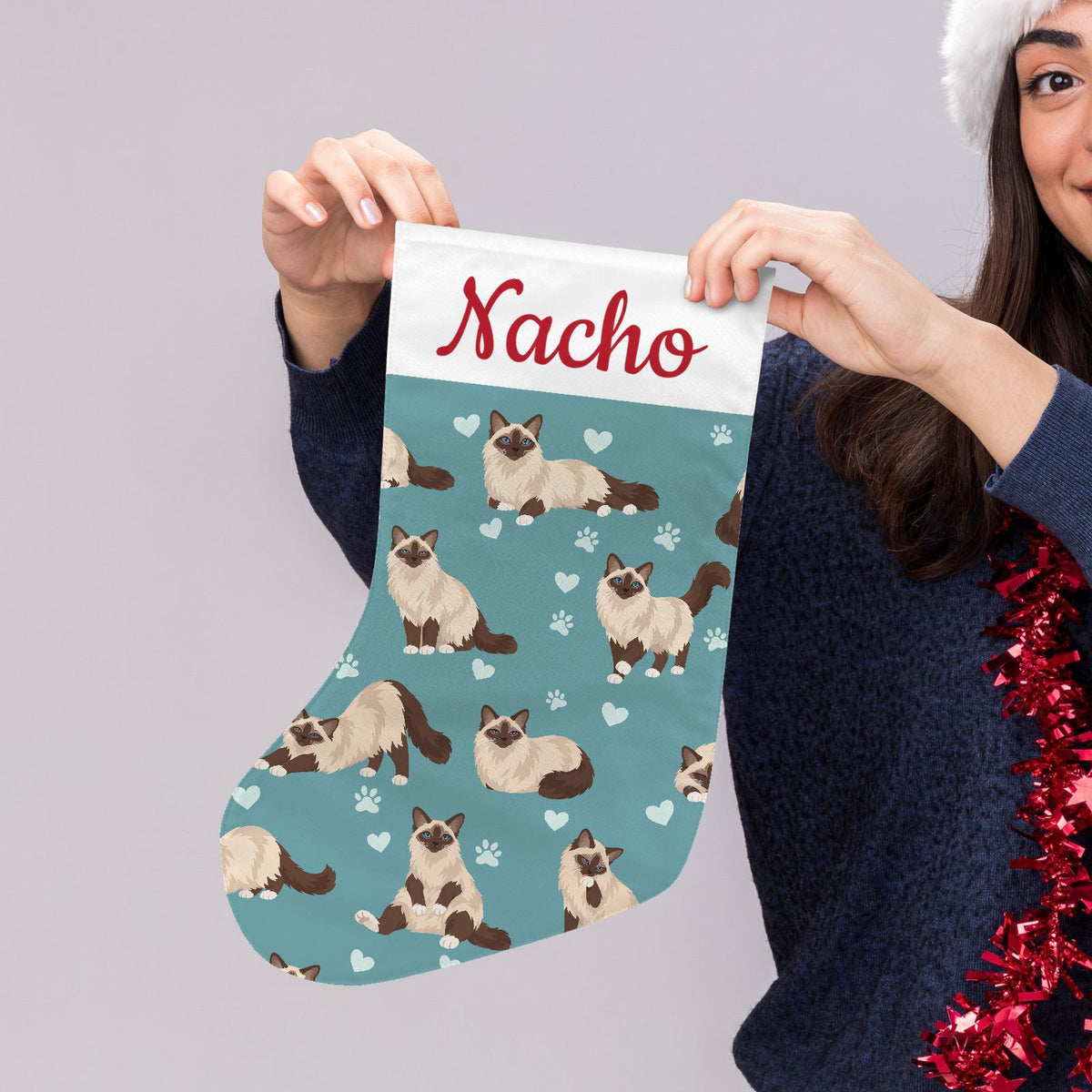 Birman Christmas stocking on muted teal background with example name Nacho in red script on the white cuff; view 5.