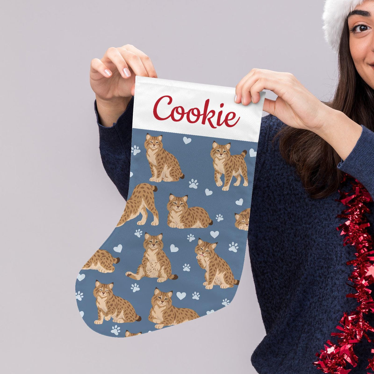 Pixie bob Christmas stocking on slate blue background with example name Cookie in red script on the white cuff; view 5.