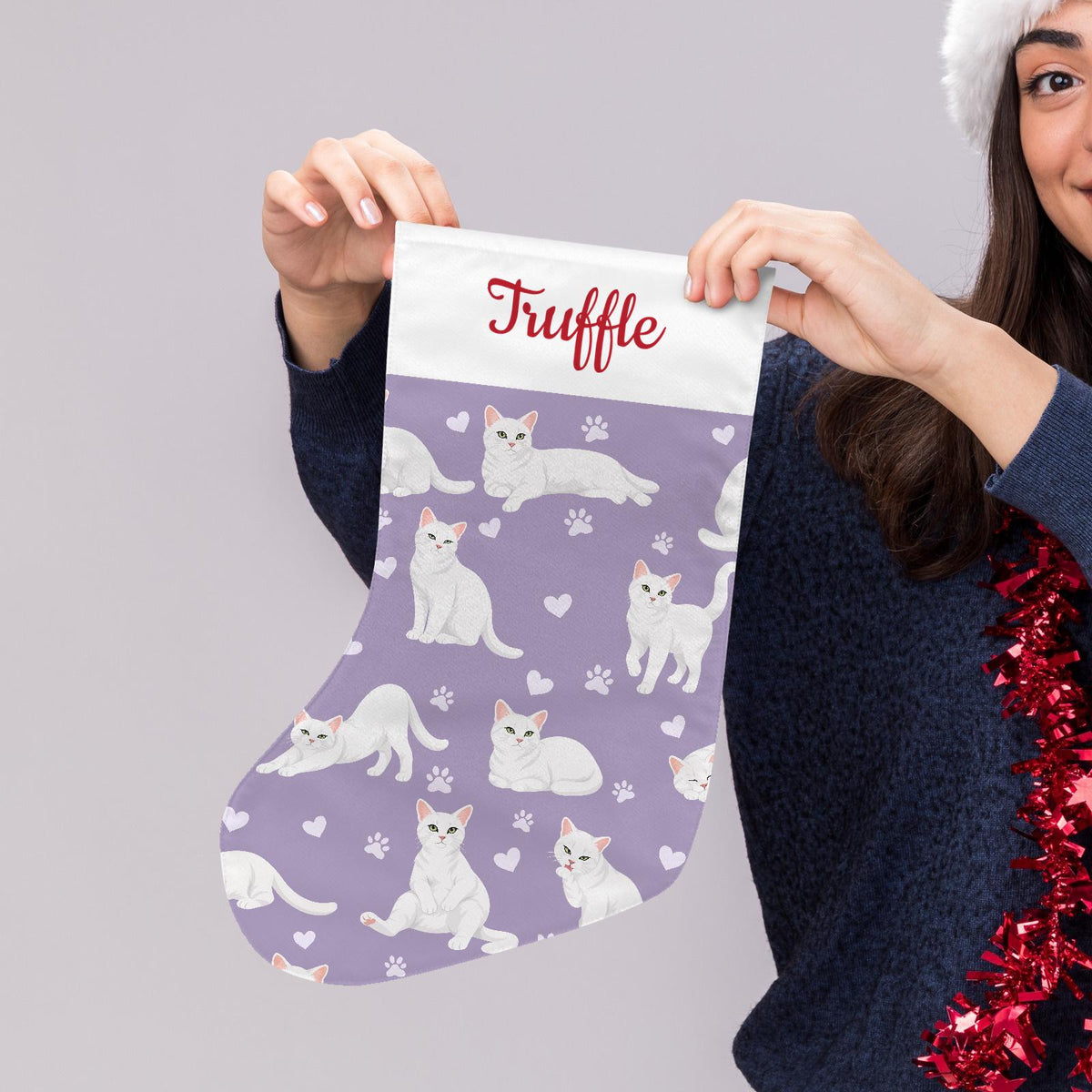 Domestic Shorthair White Christmas stocking on soft lavender background with example name Truffle in red script on the white cuff; view 5.