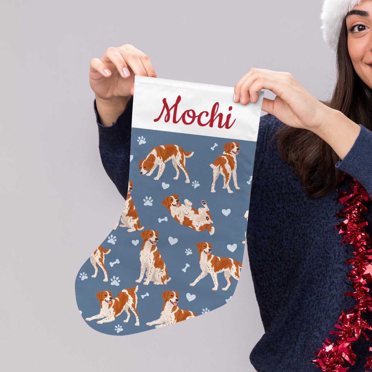 Brittany Christmas stocking on slate blue background with example name Mochi in red script on the white cuff; view 5.