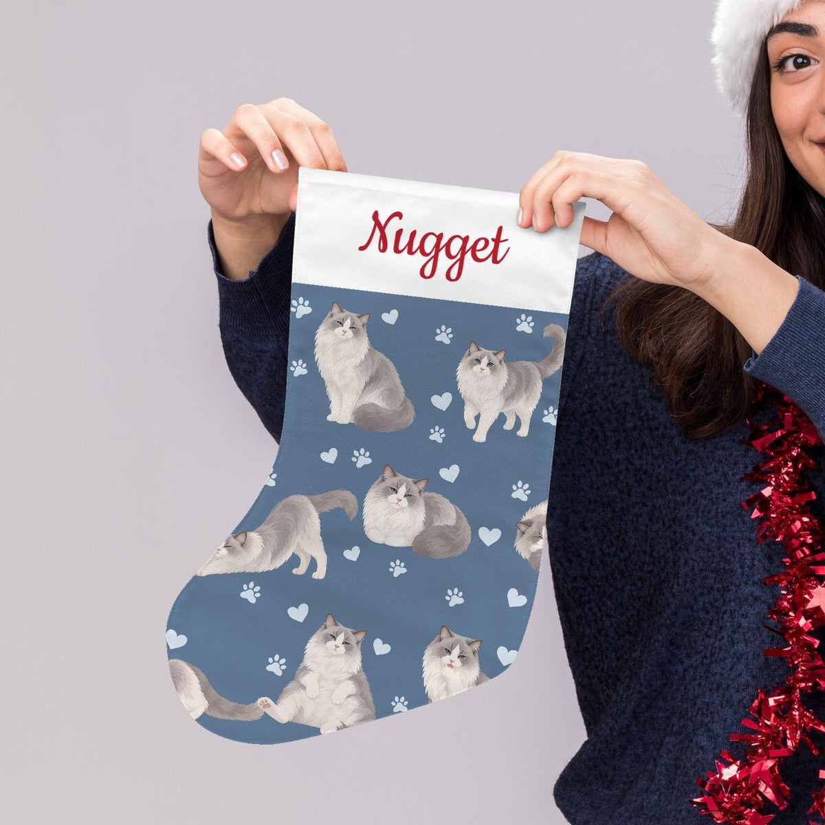 Ragdoll Christmas stocking on slate blue background with example name Nugget in red script on the white cuff; view 5.