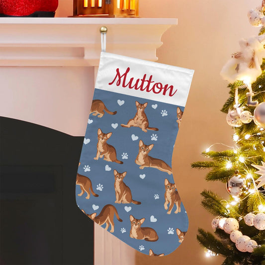 Abyssinian Christmas stocking on slate blue background with example name Mutton in red script on the white cuff; view 1.