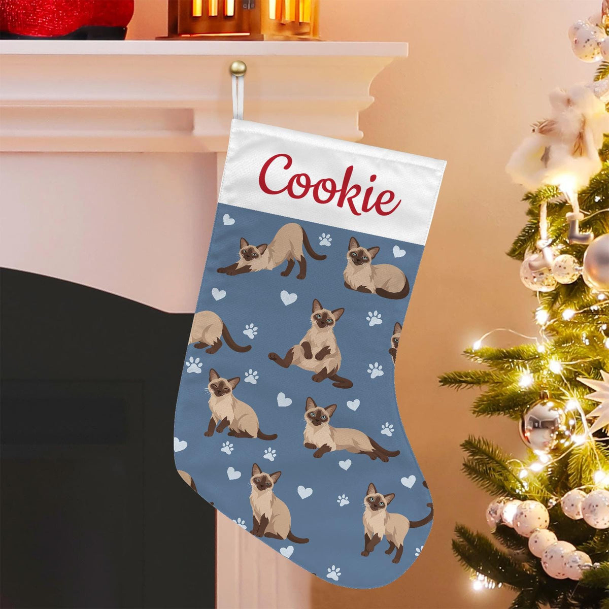 Tonkinese Christmas stocking on slate blue background with example name Cookie in red script on the white cuff; view 1.