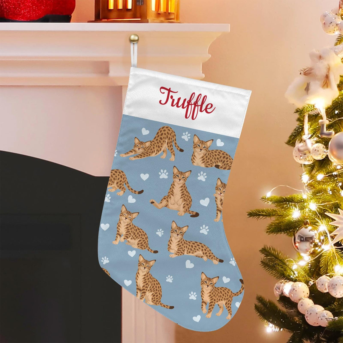 Ocicat Christmas stocking on dusty blue background with example name Truffle in red script on the white cuff; view 1.