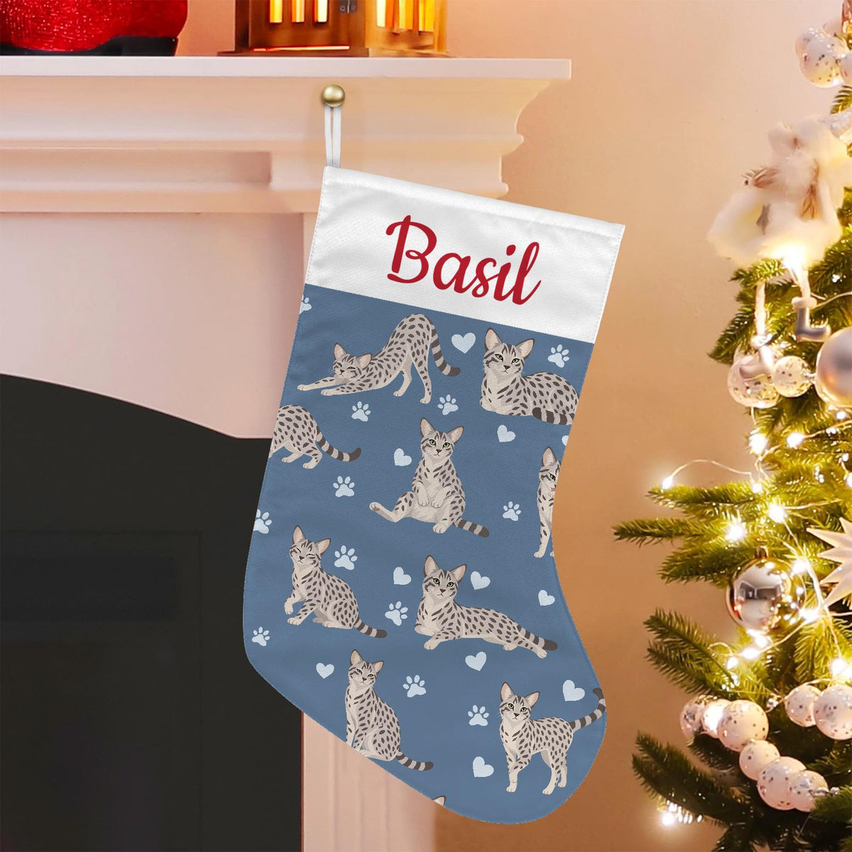 Egyptian Mau Christmas stocking on slate blue background with example name Basil in red script on the white cuff; view 1.