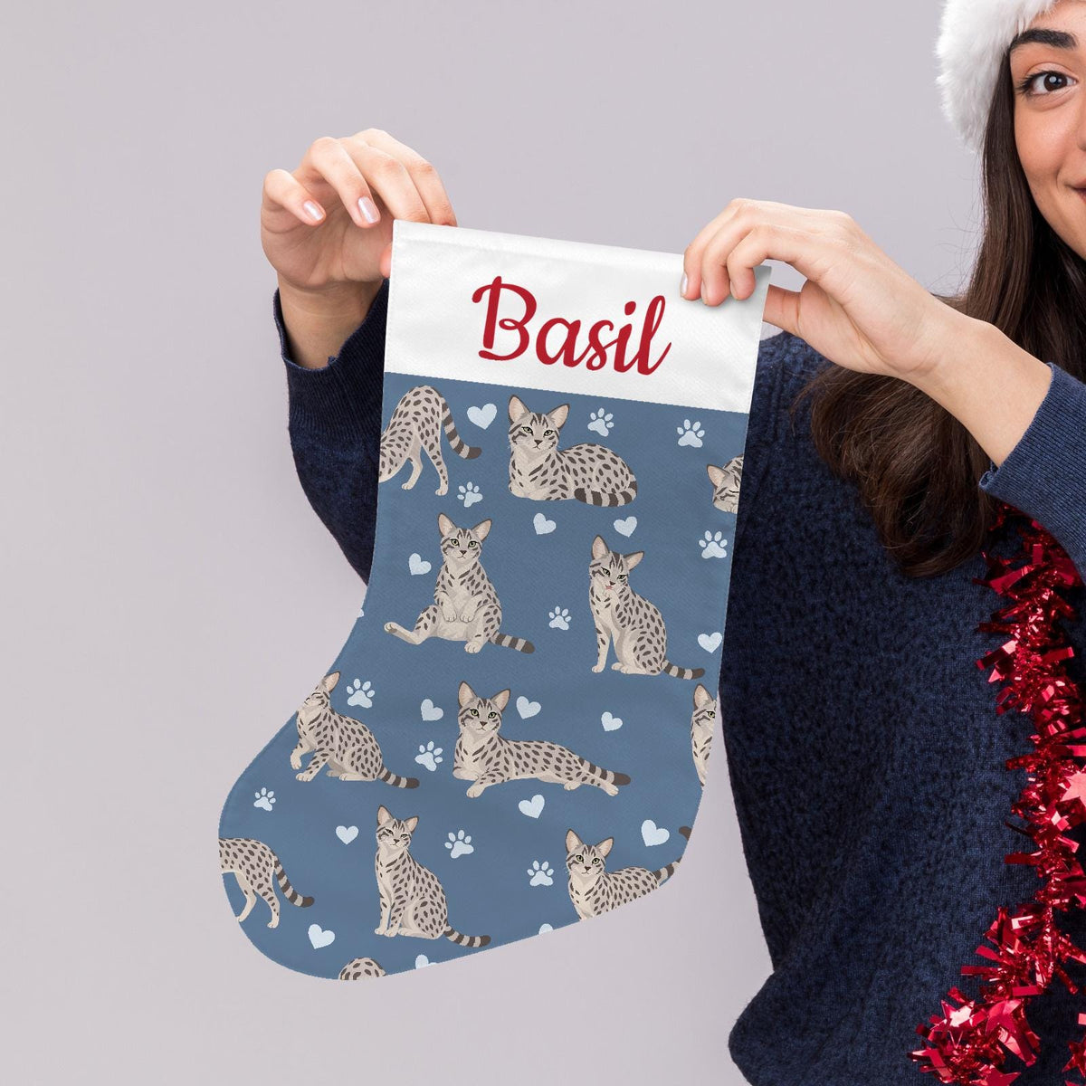Egyptian Mau Christmas stocking on slate blue background with example name Basil in red script on the white cuff; view 5.