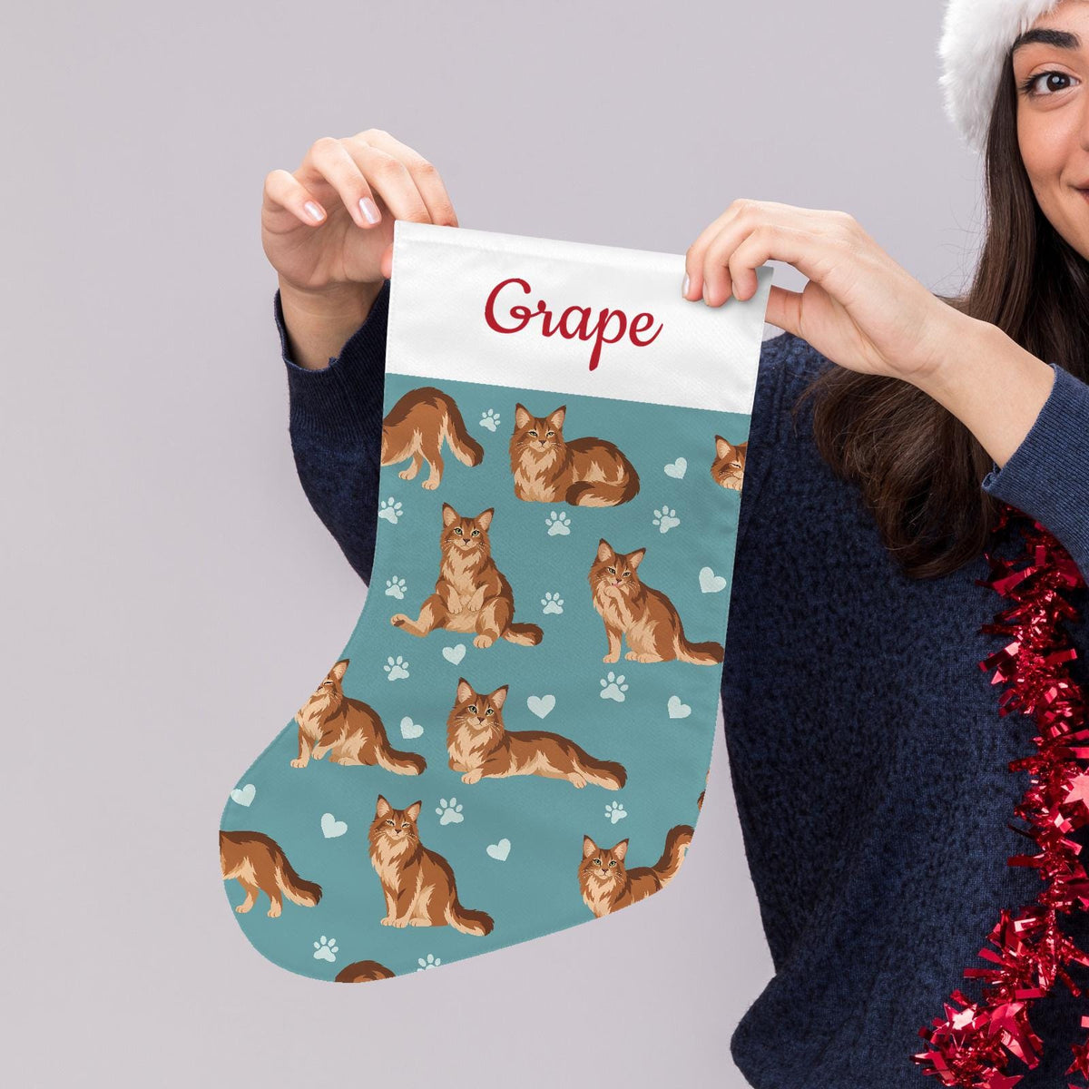 Somali Christmas stocking on muted teal background with example name Grape in red script on the white cuff; view 5.