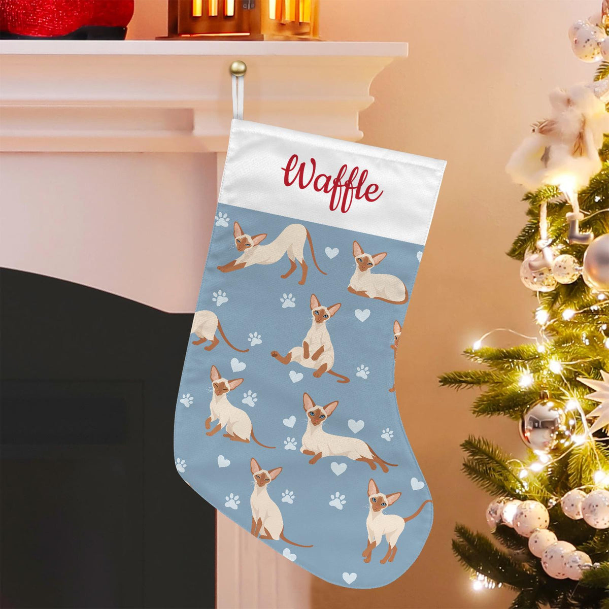 Colorpoint Shorthair Christmas stocking on dusty blue background with example name Waffle in red script on the white cuff; view 1.