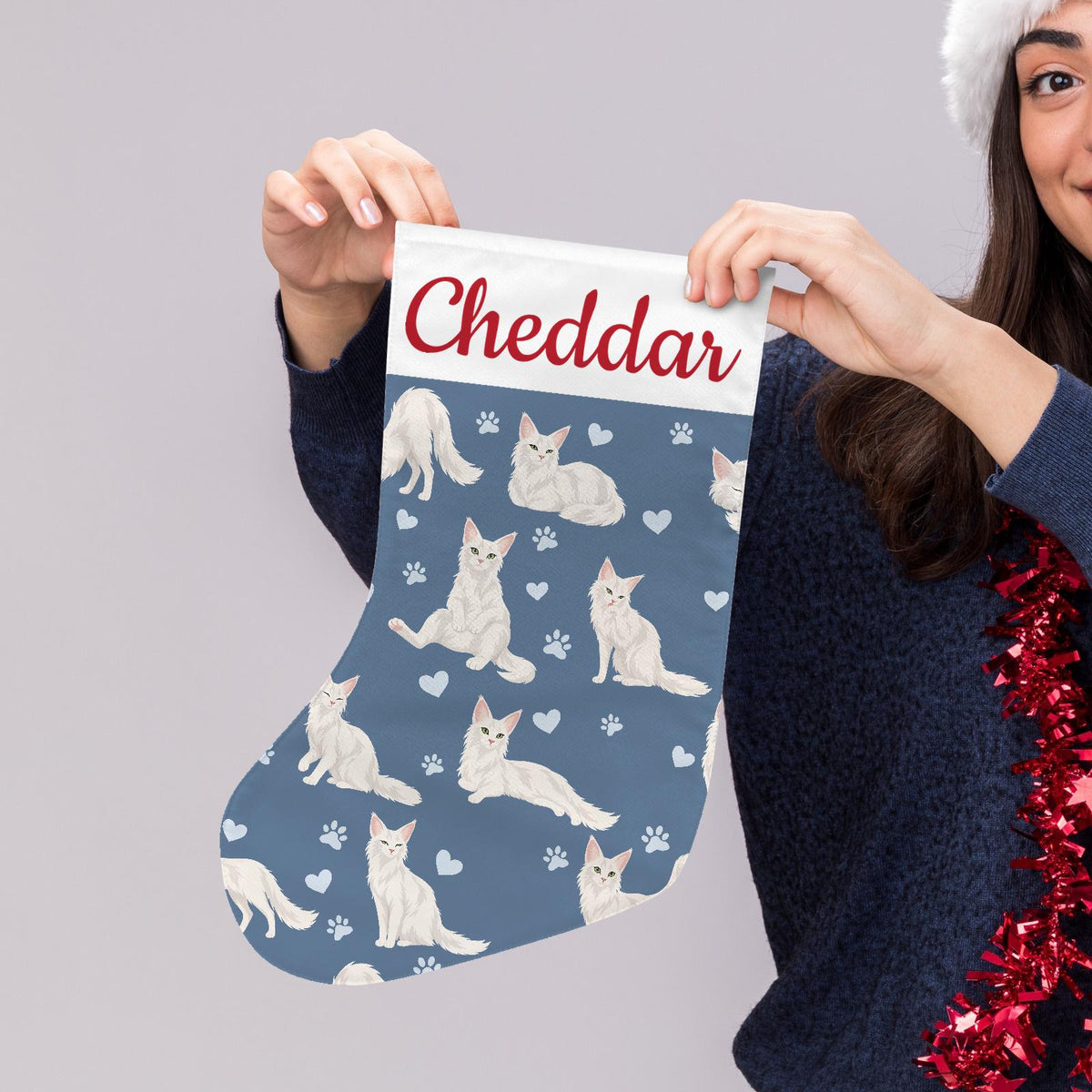 Turkish Angora Christmas stocking on slate blue background with example name Cheddar in red script on the white cuff; view 5.