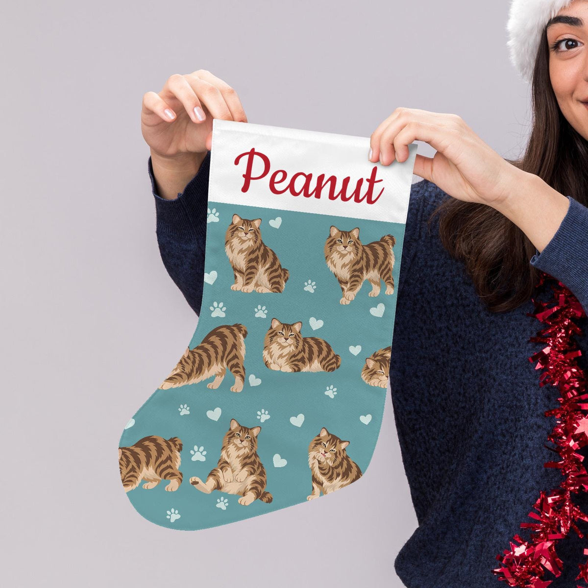 American Bobtail Christmas stocking on muted teal background with example name Peanut in red script on the white cuff; view 5.