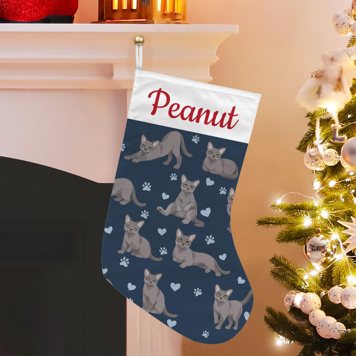 Korat Christmas stocking on deep navy background with example name Peanut in red script on the white cuff; view 1.