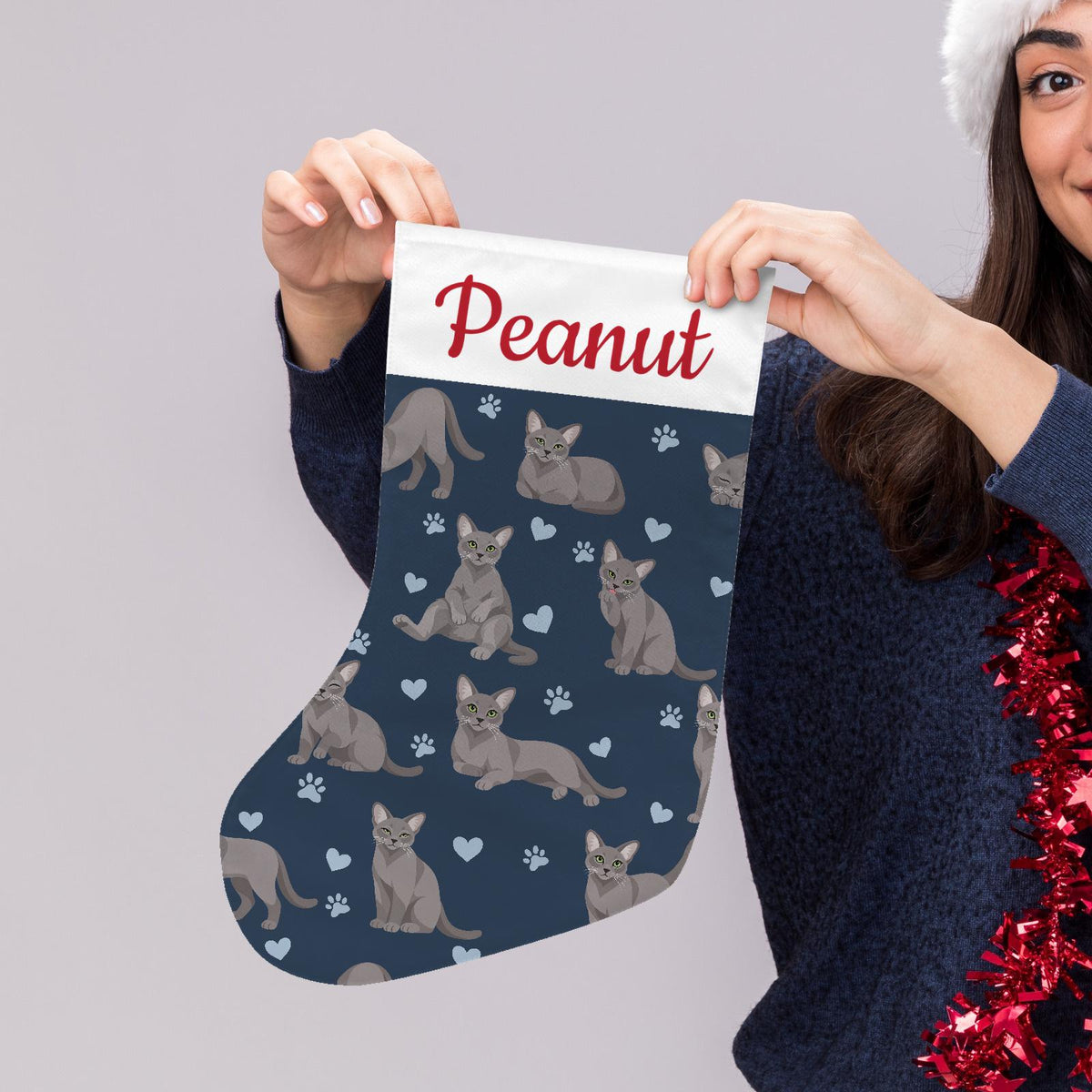 Korat Christmas stocking on deep navy background with example name Peanut in red script on the white cuff; view 5.
