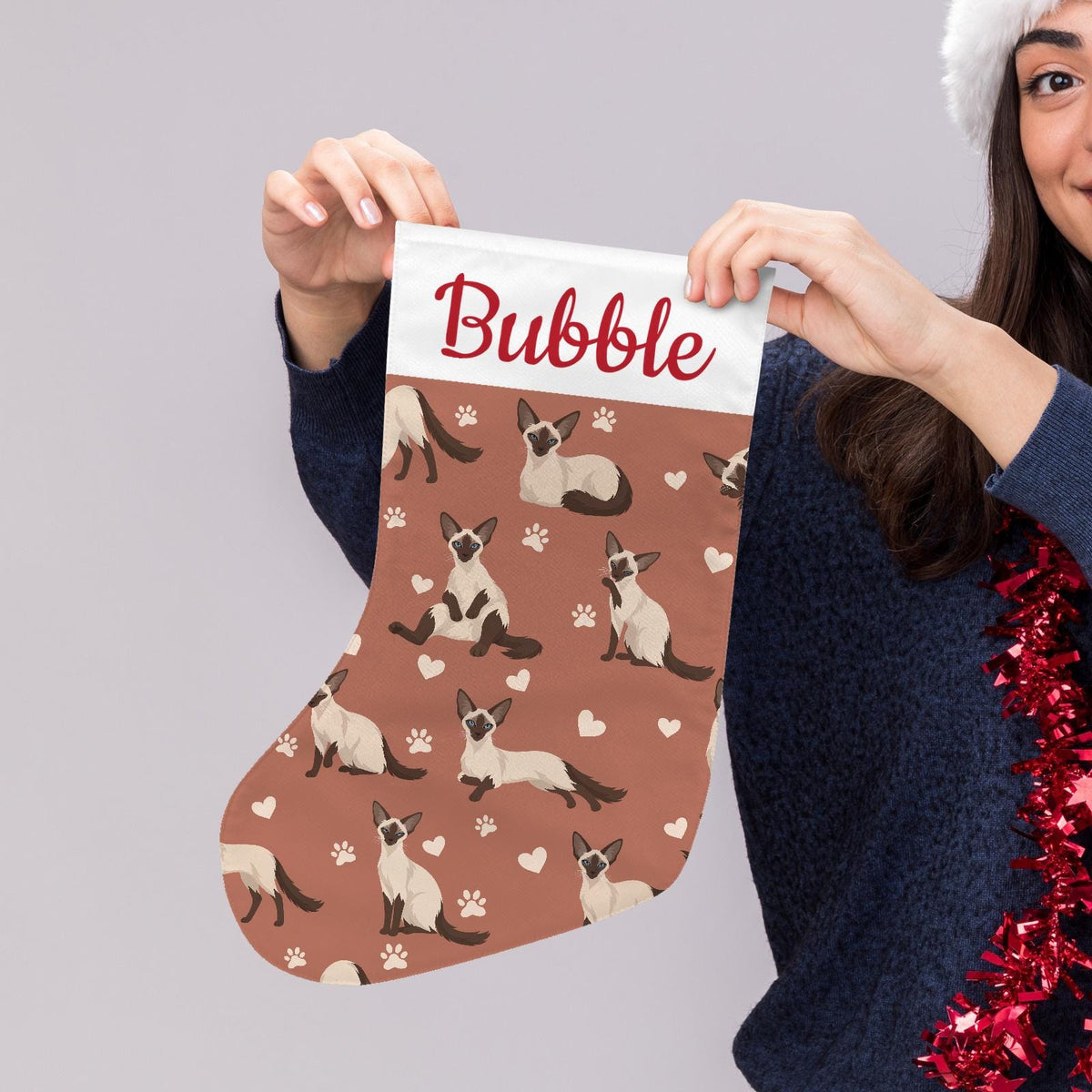 Balinese Christmas stocking on muted terracotta background with example name Bubble in red script on the white cuff; view 5.