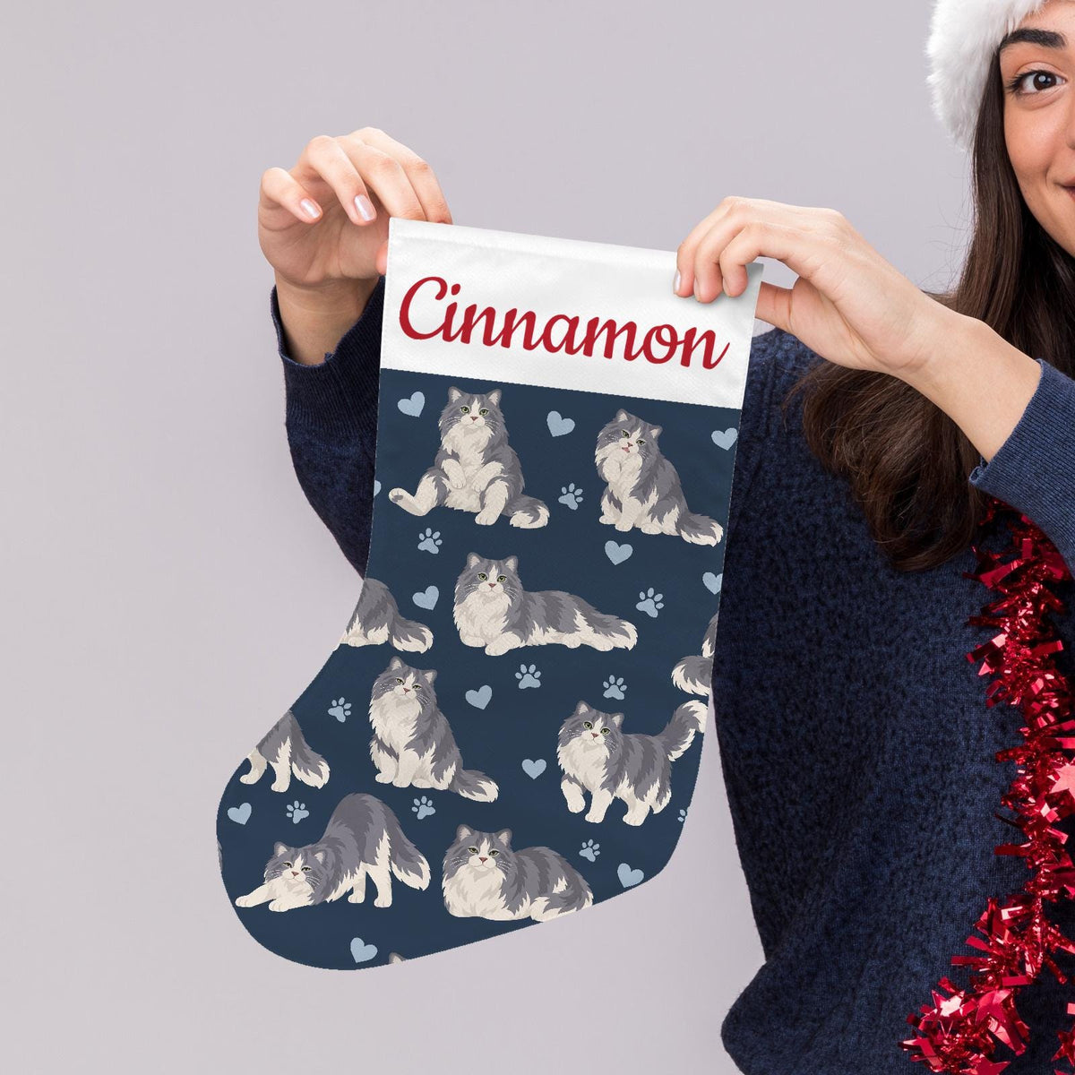 Ragamuffin Christmas stocking on deep navy background with example name Cinnamon in red script on the white cuff; view 5.