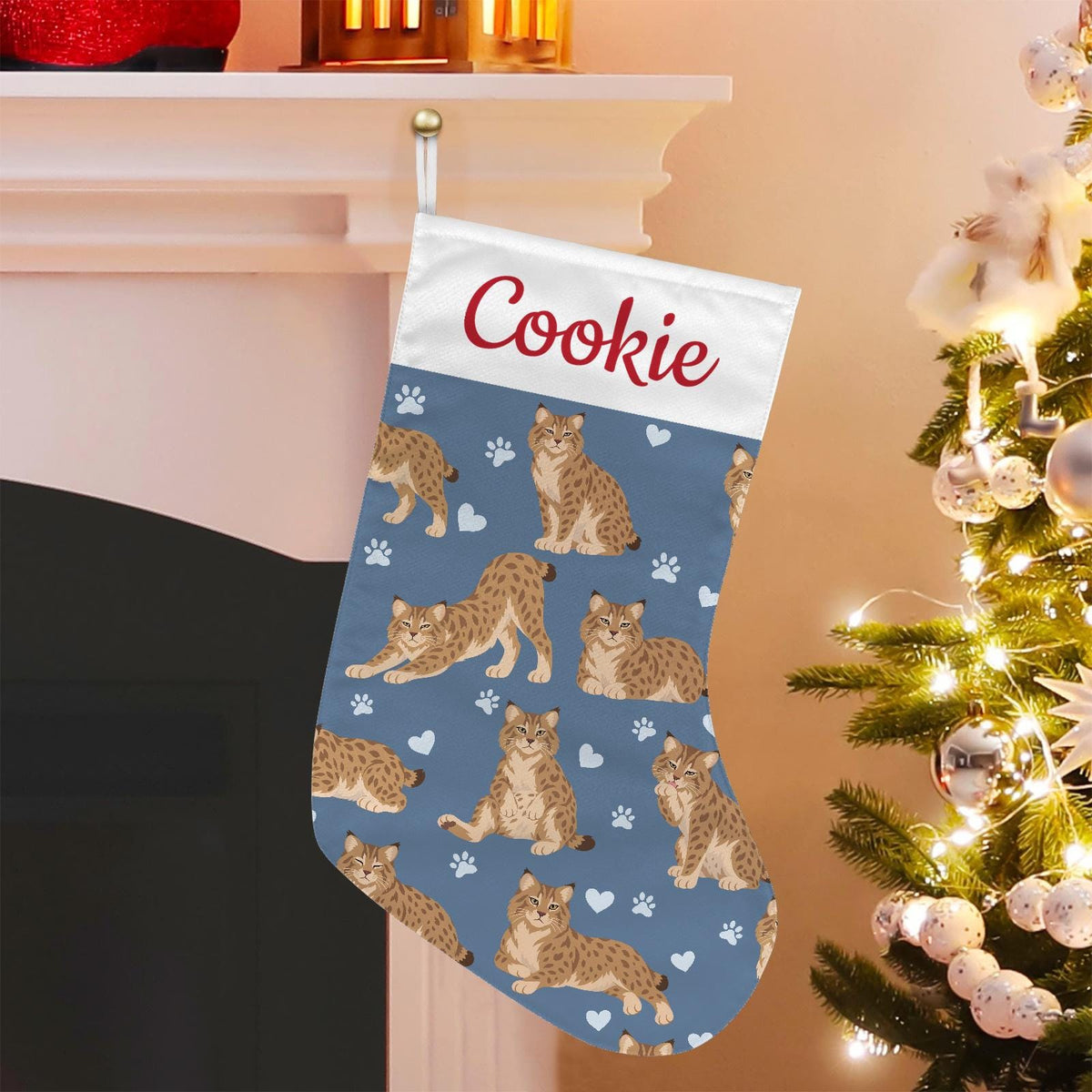 Pixie bob Christmas stocking on slate blue background with example name Cookie in red script on the white cuff; view 1.