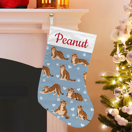 Toyger Christmas stocking on dusty blue background with example name Peanut in red script on the white cuff; view 1.
