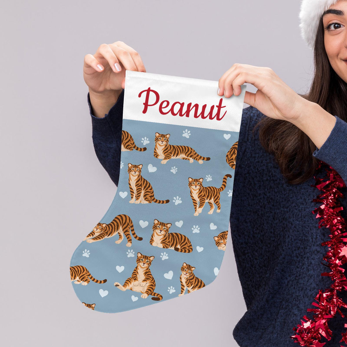 Toyger Christmas stocking on dusty blue background with example name Peanut in red script on the white cuff; view 5.