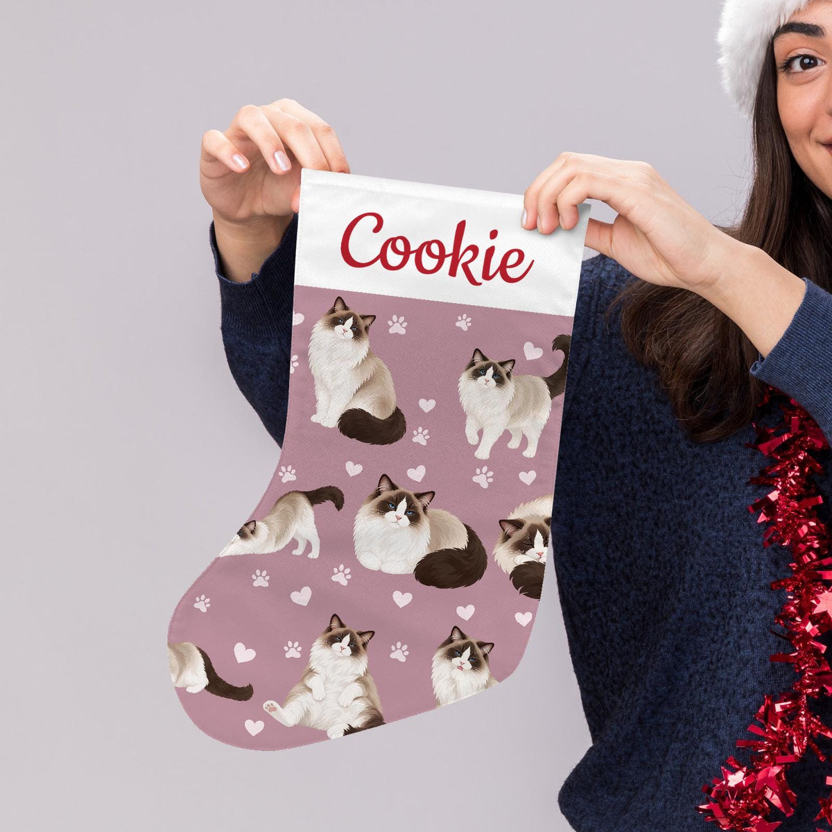 Ragdoll Seal bicolor Christmas stocking on dusty rose background with example name Cookie in red script on the white cuff; view 5.