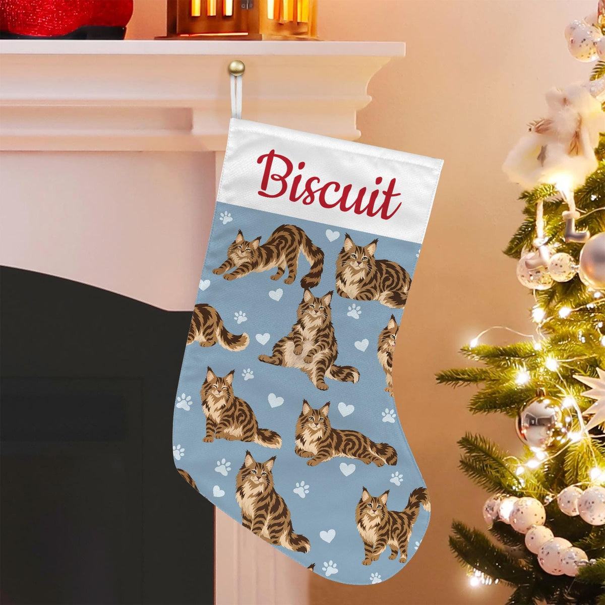 Maine Coon Brown classic tabby Christmas stocking on dusty blue background with example name Biscuit in red script on the white cuff; view 1.