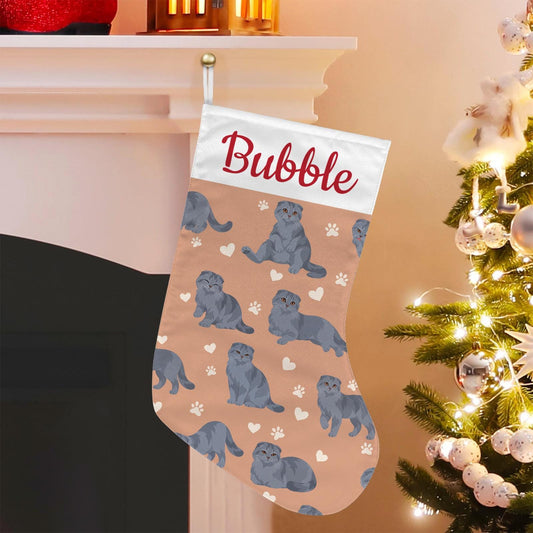 Scottish Fold Solid blue gray Christmas stocking on peach background with example name Bubble in red script on the white cuff; view 1.