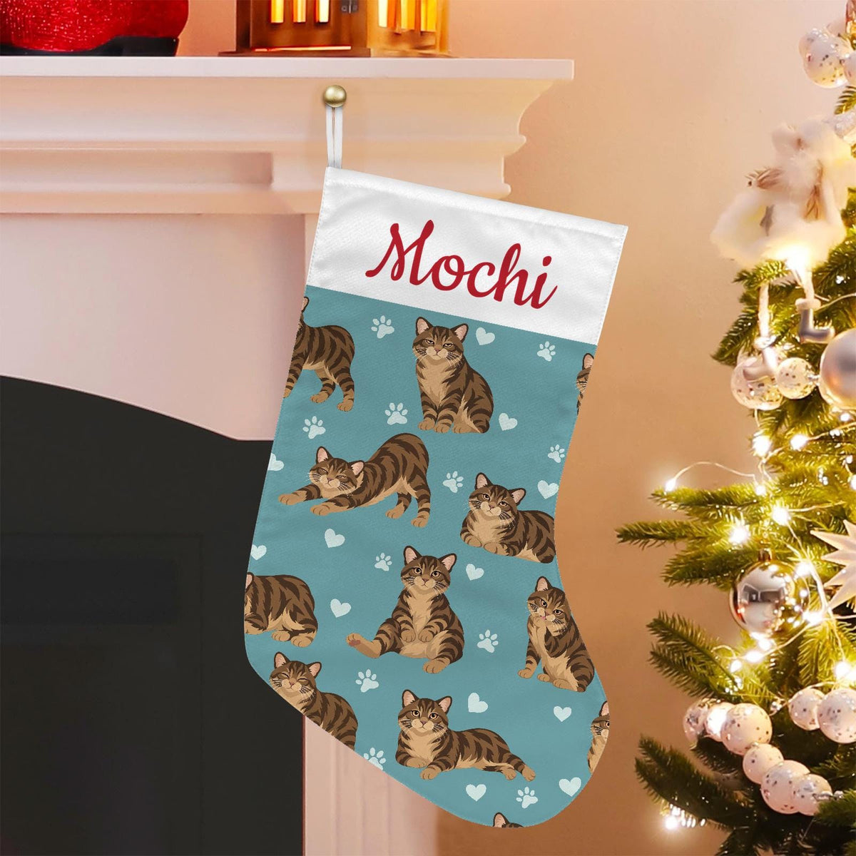 Manx Brown tabby Christmas stocking on muted teal background with example name Mochi in red script on the white cuff; view 1.