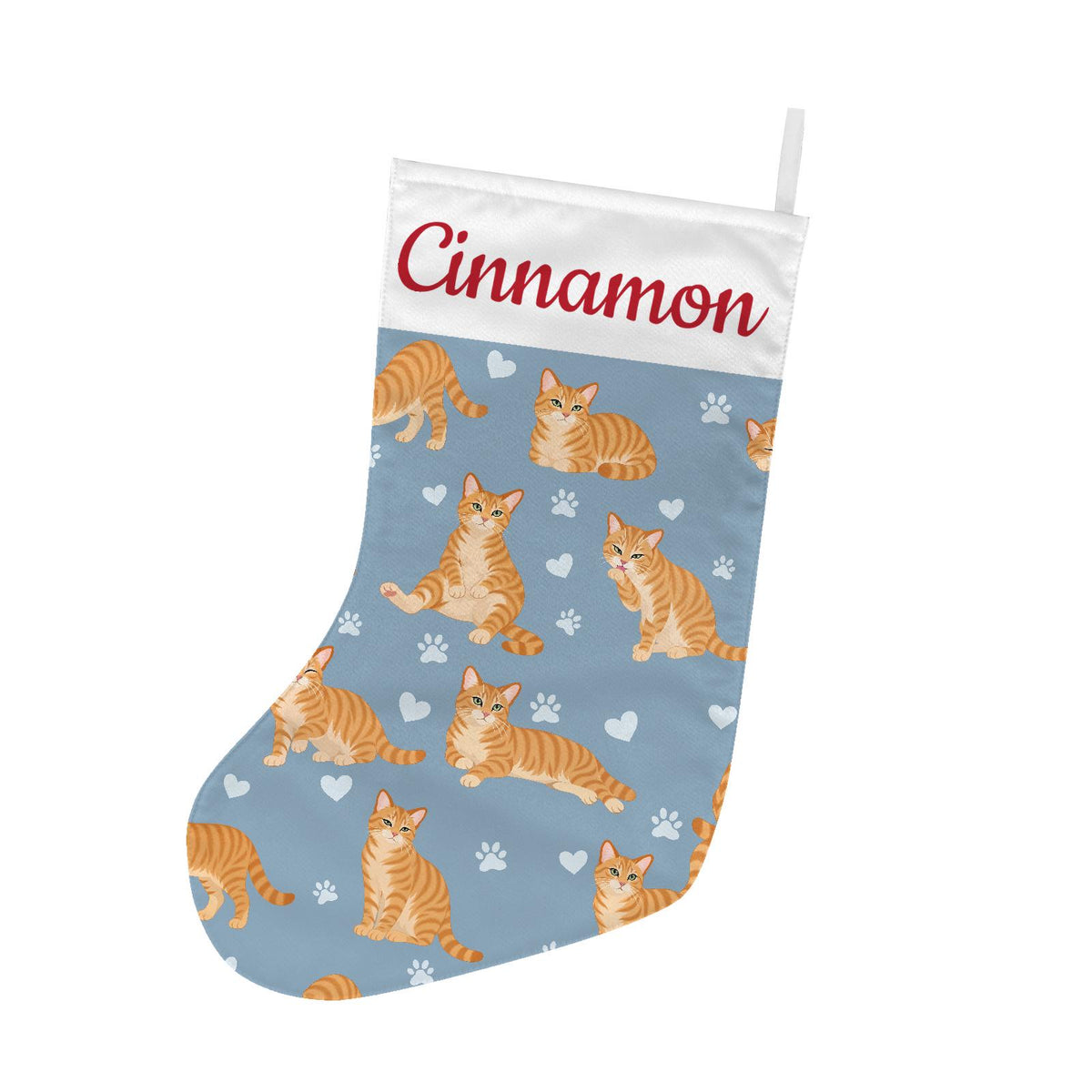 Domestic Shorthair Orange Christmas stocking on dusty blue background with example name Cinnamon in red script on the white cuff; view 2.