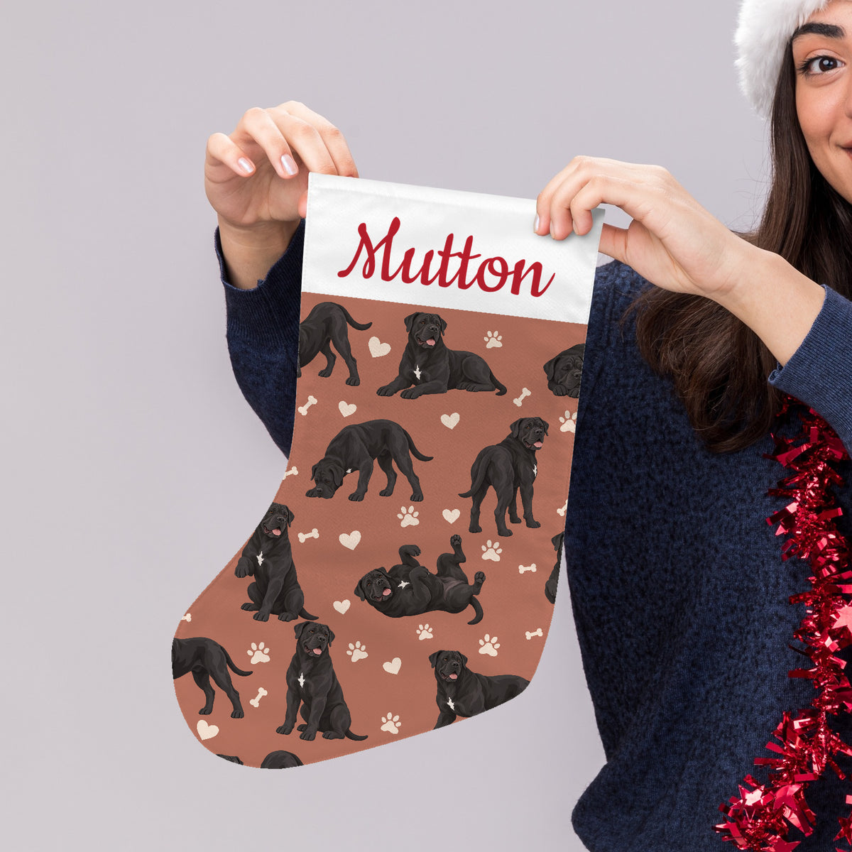 Cane Corso Christmas stocking on muted terracotta background with example name Mutton in red script on the white cuff; view 4.
