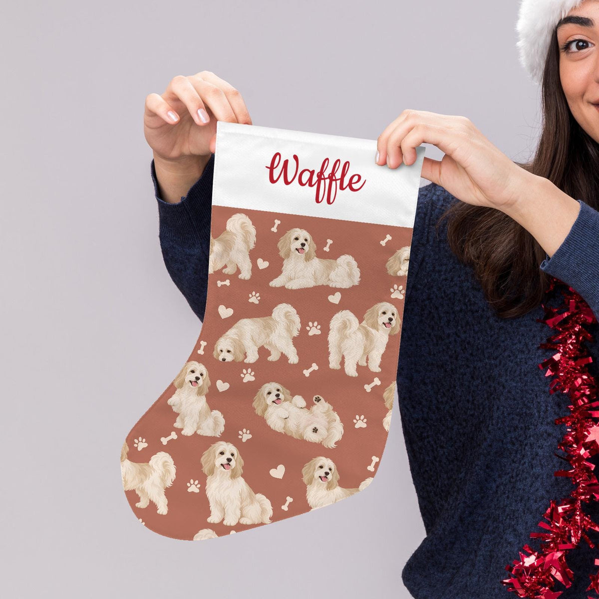 Havanese Christmas stocking on muted terracotta background with example name Waffle in red script on the white cuff; view 5.