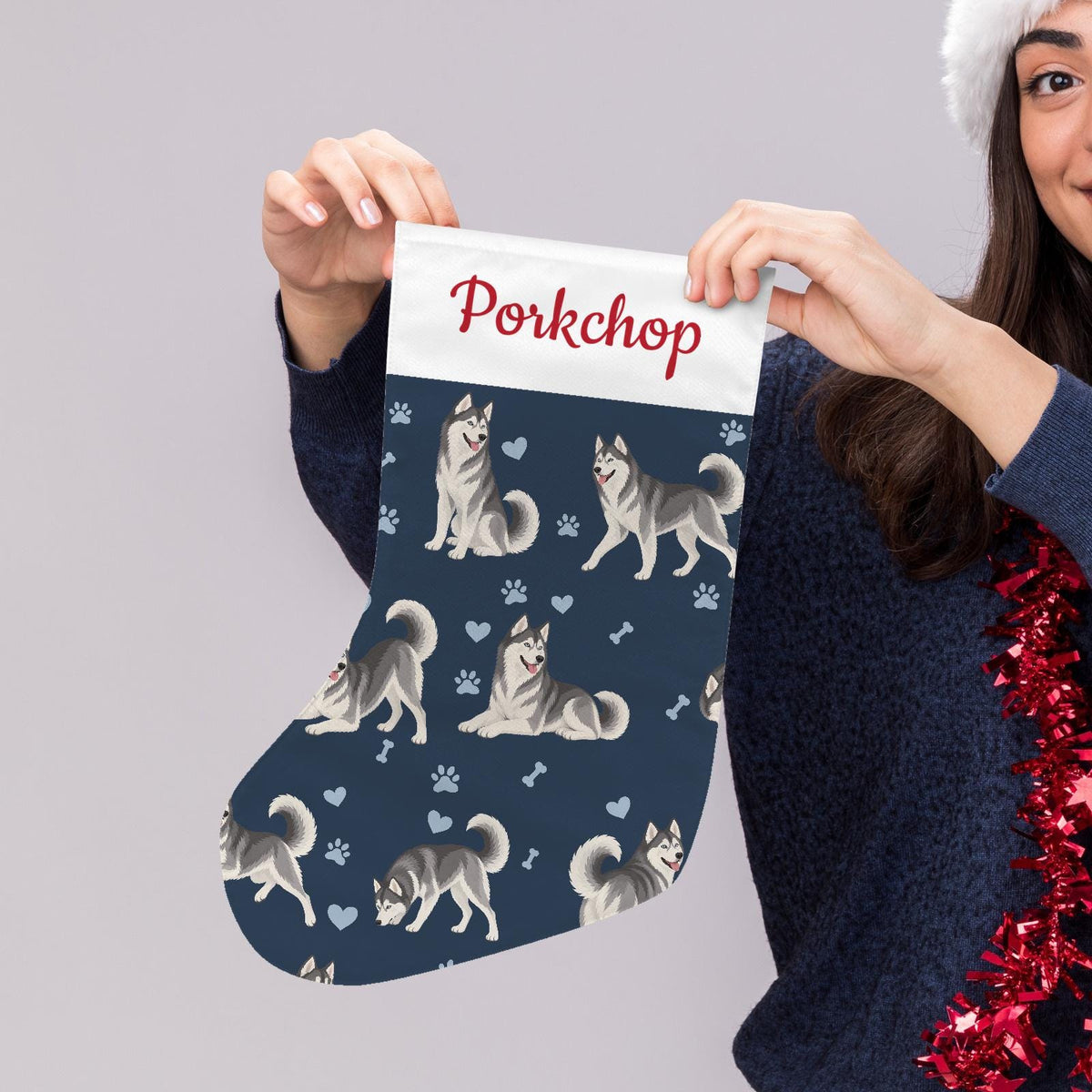 Siberian Husky Christmas stocking on deep navy background with example name Porkchop in red script on the white cuff; view 5.