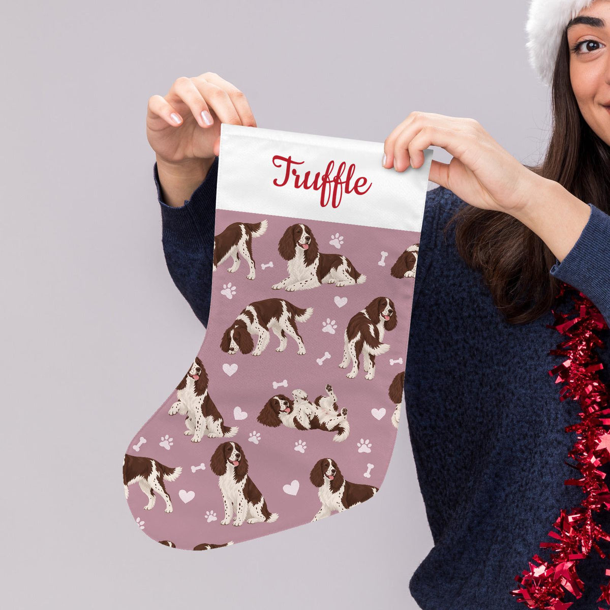 English Springer Spaniel Christmas stocking on dusty rose background with example name Truffle in red script on the white cuff; view 5.