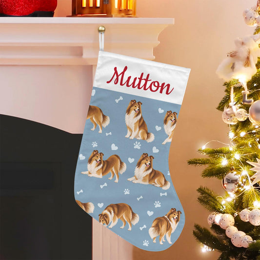Shetland Sheepdog Christmas stocking on dusty blue background with example name Mutton in red script on the white cuff; view 1.