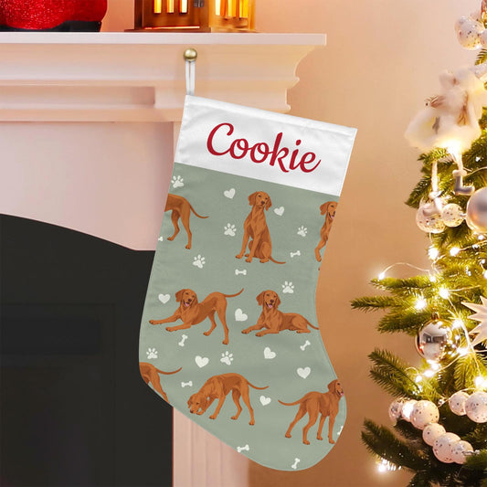 Vizsla Christmas stocking on soft sage background with example name Cookie in red script on the white cuff; view 1.
