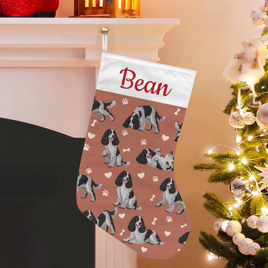 English Cocker Spaniel Christmas stocking on muted terracotta background with example name Bean in red script on the white cuff; view 1.