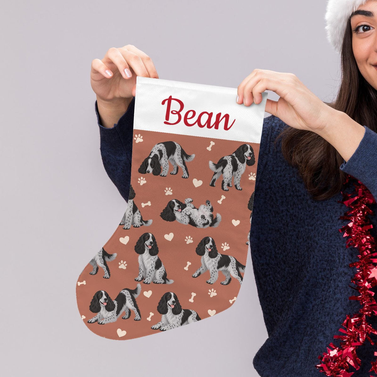 English Cocker Spaniel Christmas stocking on muted terracotta background with example name Bean in red script on the white cuff; view 5.