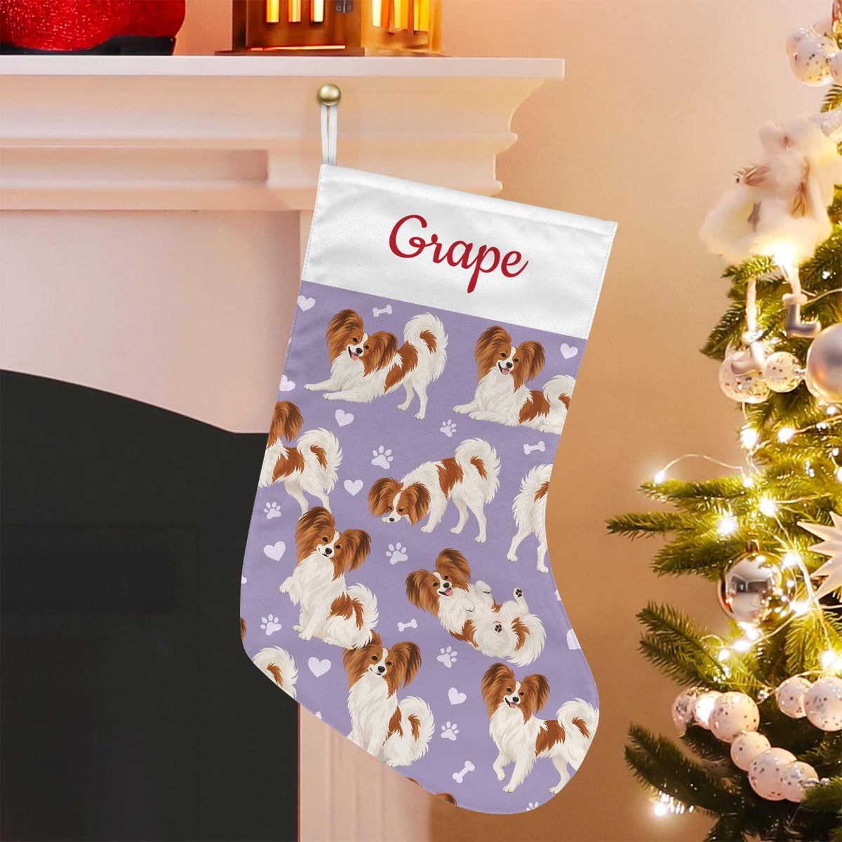 Papillon Christmas stocking on soft lavender background with example name Grape in red script on the white cuff; view 1.
