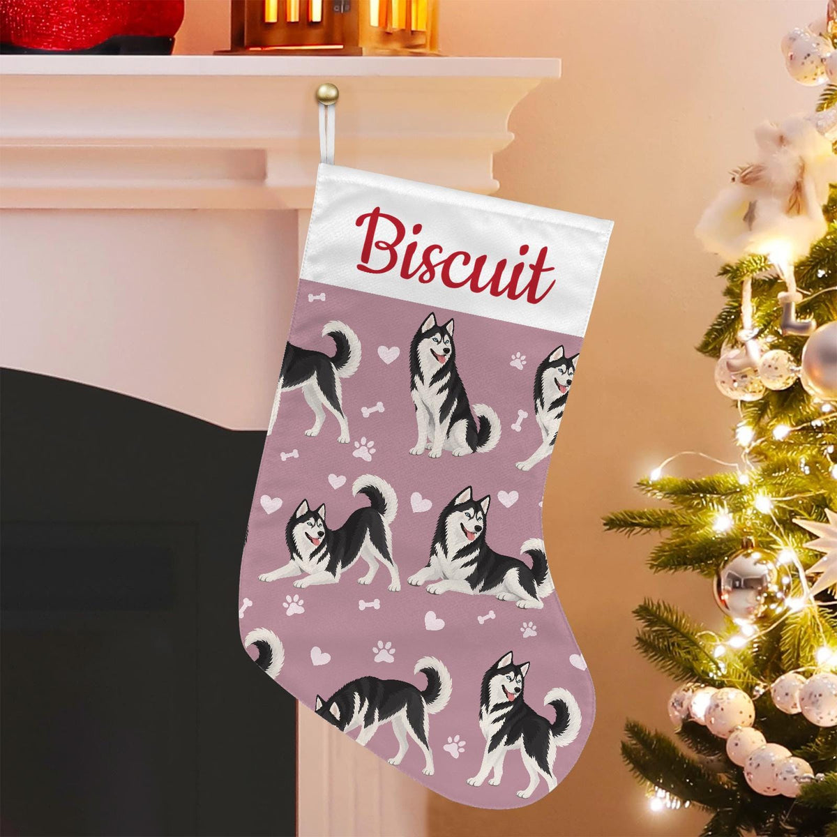 Siberian Husky Black and White Christmas stocking on dusty rose background with example name Biscuit in red script on the white cuff; view 1.