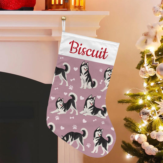 Siberian Husky Black and White Christmas stocking on dusty rose background with example name Biscuit in red script on the white cuff; view 1.