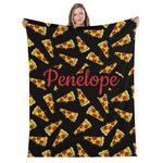 A woman is holding up a black blanket with a repeating pattern of yellow and red pizza slices.