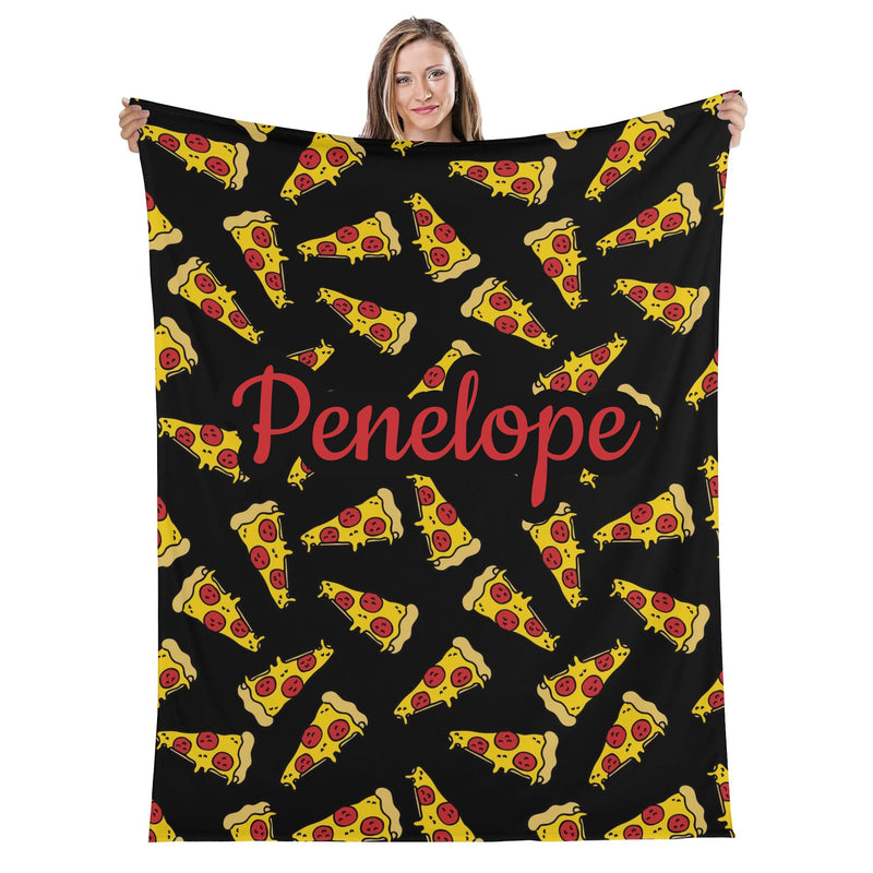 A woman is holding up a black blanket with a repeating pattern of yellow and red pizza slices.