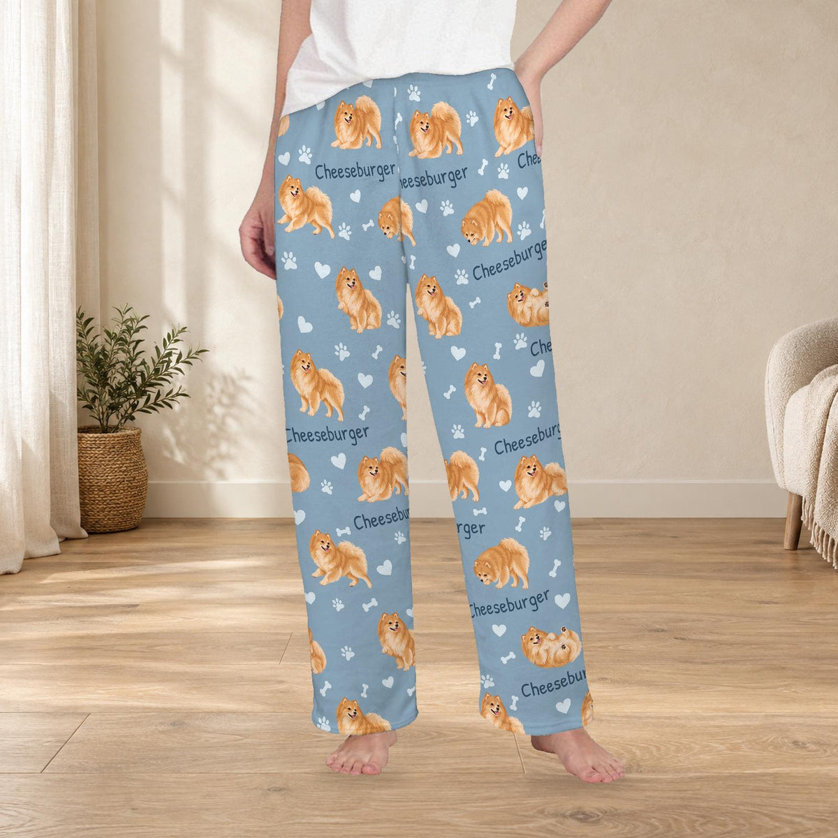 Pomeranian personalized fleece pajama trousers on a model; women's fit, front view. Cozy neutral room background.