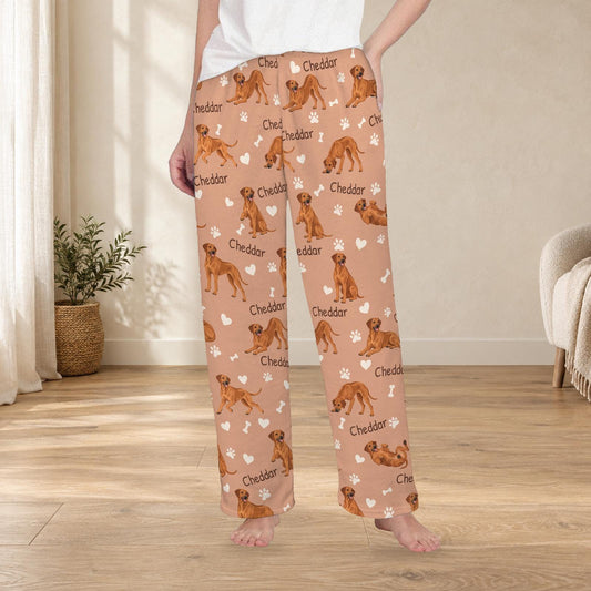Rhodesian Ridgeback personalized fleece pajama trousers on a model; women's fit, front view. Cozy neutral room background.